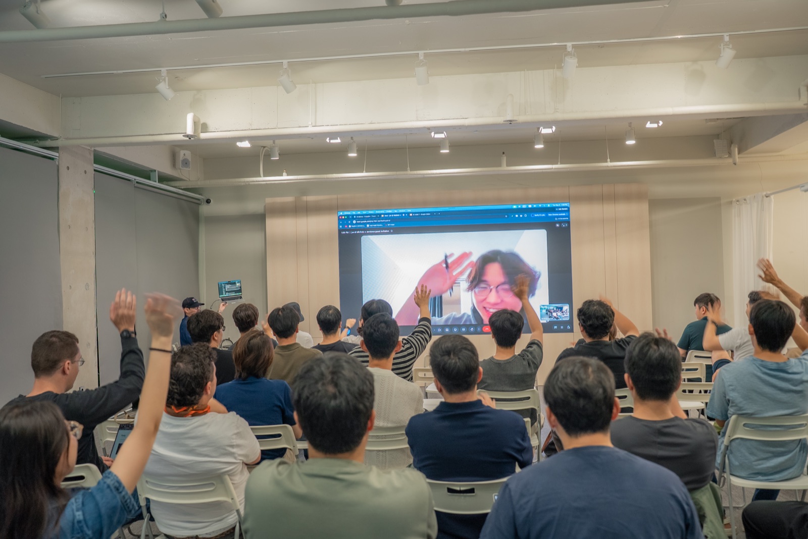Founders waving to a guest joining by video call